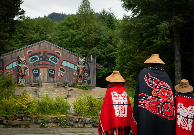 Photo of dancers and Beaver Clan house